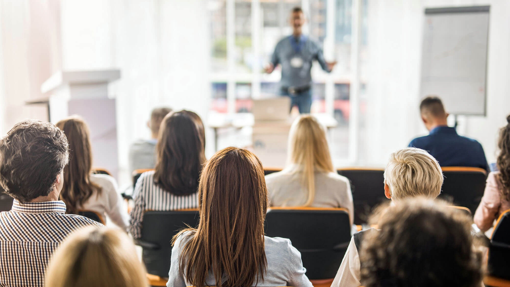 Rear view of business people attending a seminar in board room